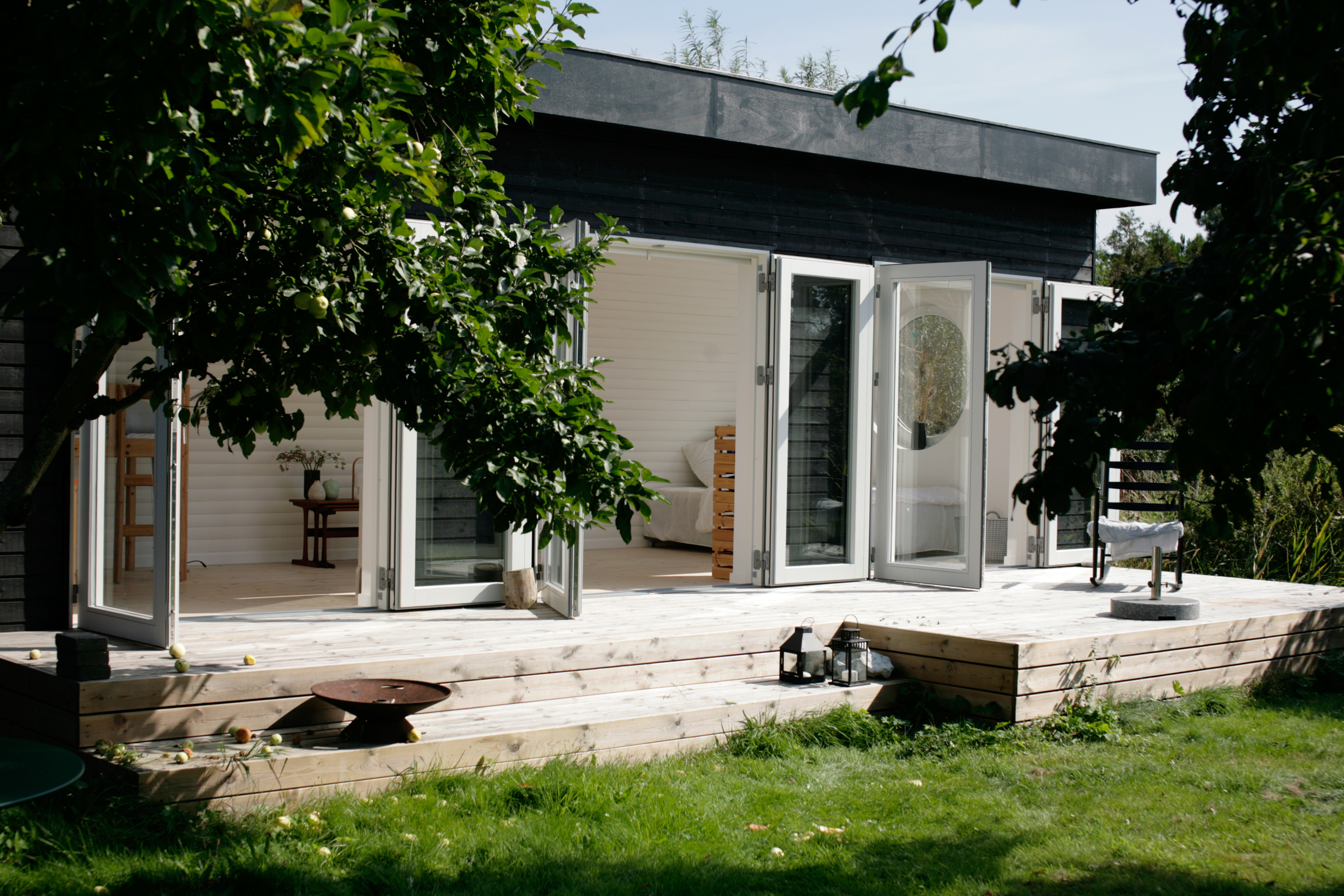 Sort anneks med foldedøre og træterrasse