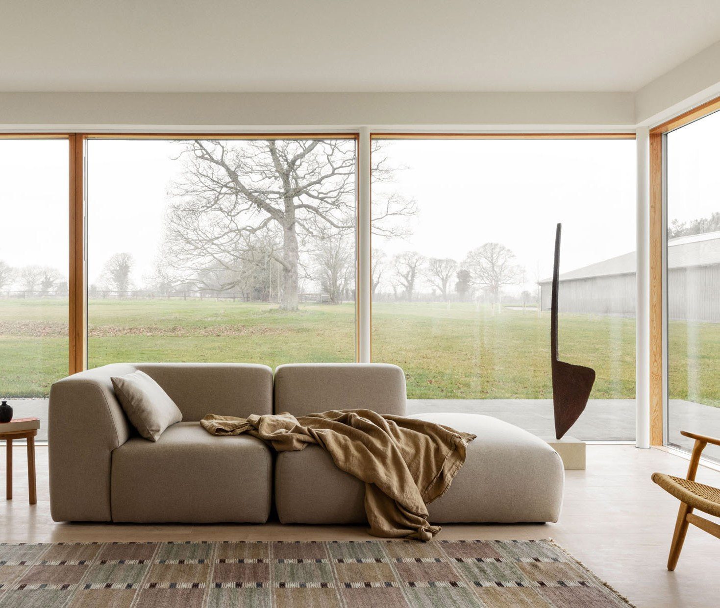 Lang – opholdsrum med sofa mod glasfacaden